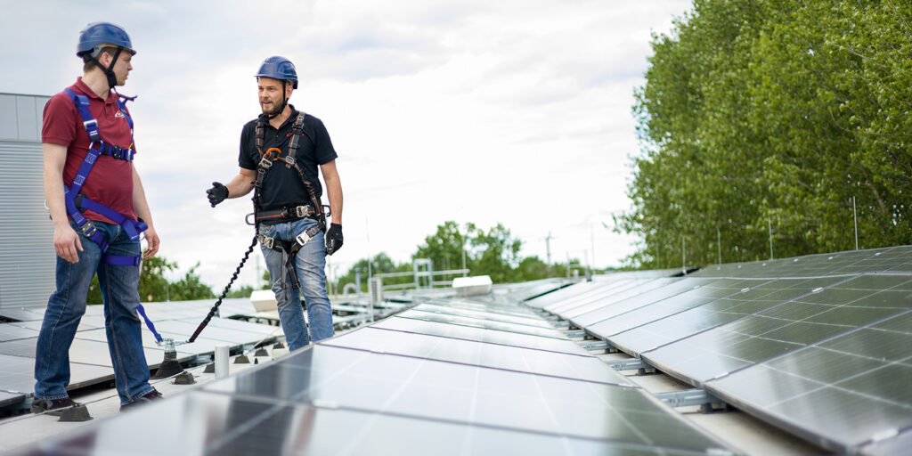 Gesprächssituation bei Photovoltaikanlagen zweier Takeda-Mitarbeiter; Abb. Takeda / Martin Buschmann