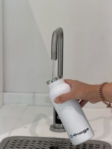 Wasser läuft aus einem Hahn in eine Flasche. Quelle: Thüga