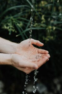 Schmuckbild, Hände unter einem fließenden Wasserstrahl, Quelle: Austin Kehmeier / Unsplash