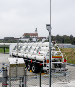 LKW-Anhänger mit langen, weißen Gasflaschen zum Transport von H2